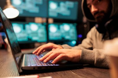 Male hacker using security breach to hack server, hacking computer system to create malware and steal information online. Dangerous criminal producing cyber attack to break software network.