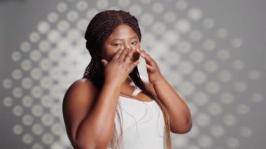Beauty model applying face cream to create skincare ad, using moisturizer or serum to nourish glowing skin with imperfections. Young woman being gentle with creams on cheeks, natural girl.