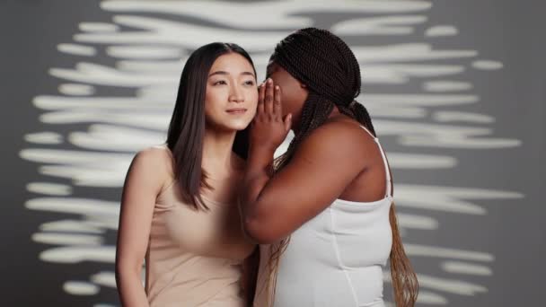 Mujer Afroamericana Susurrando Secreto Chica Asiática Cámara Actuando Sensual Glamoroso — Vídeos de Stock