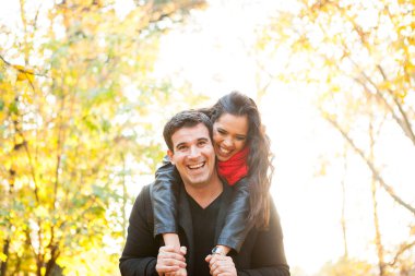 Beautiful romantic couple in autumn park having fun