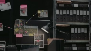 Empty incident room with criminal case investigation, board with clues and evidence. Suspicious research photos and file folders on racks, federal confidential documents in agency office.