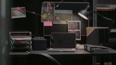 Criminal evidence board in investigation office, map filled with research photos and case clues. Police archive space with background check papers and crime suspects, law officer expertise.
