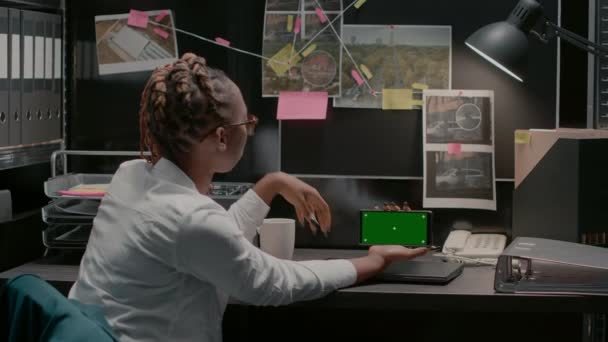アーカイブ室のグリーンスクリーンを利用した若手検査員 クロマキーディスプレイの検討と調査を行う コピースペースで隔離されたモックアップテンプレートをチェック — ストック動画
