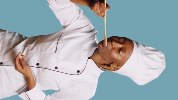 Вертикальное Видео Африканский Американский Повар Делает Тест Вкуса Еды Ложкой — стоковое видео