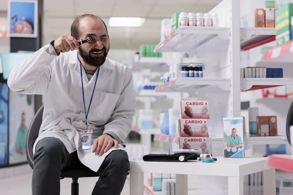 Pharmacist Standing Chair Empty Pharmacy Holding Medical Otoscope Looking Camera — 스톡 사진