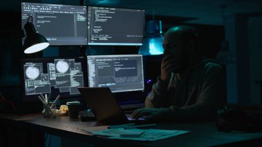 Erkek programcı esniyor ve yeni arayüz üzerinde çalışıyor, gece geç saatlerde uykulu hissediyor. Yorgun yazılım mühendisi, güvenlik sistemi oluşturmak için veri tabanı bilgilerini yazmaktan yoruldu, yoruldu. El kamerasıyla..