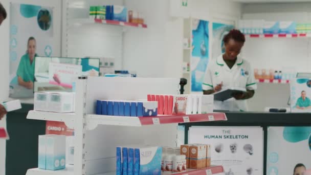 Afroamerykanka Patrząca Medycynę Regałach Kupująca Leki Produkty Farmaceutyczne Aptece Kobieta — Wideo stockowe