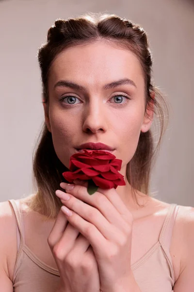 美丽的时尚模特儿 嘴边挂着红花肖像 迷人的年轻高加索女人亲吻着玫瑰花瓣 在镜头前流露出爱与柔情 — 图库照片