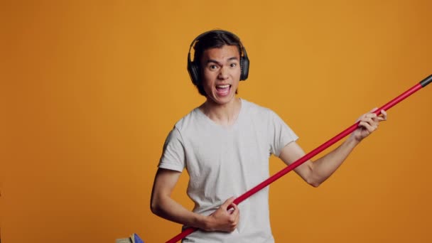 Asiatisk Bekymmerslös Kille Spelar Gitarr Med Kvast Rolig Kameran Lyssnar — Stockvideo