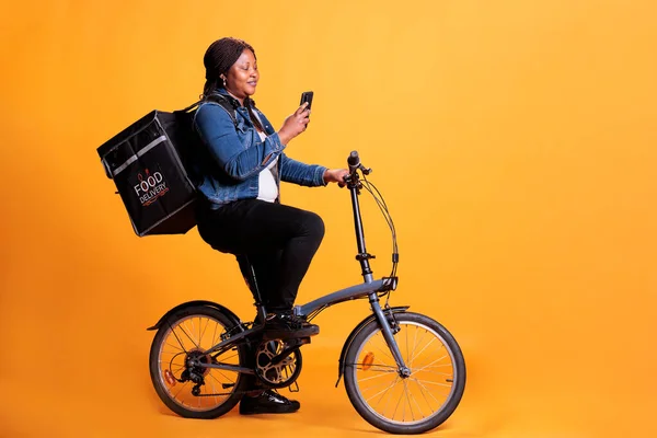 Afrika Kökenli Amerikalı Kadın Teslimatı Sarı Arka Planda Bisikletle Stüdyoda — Stok fotoğraf