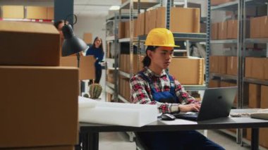 Asyalı adam depoya sipariş sevkiyatı yapmayı planlıyor, kadın çalışanlarla birlikte malzeme zinciri için paket gönderiyorlar. Mal ve ürünleri kontrol eden bir grup insan, küçük işletmeler..