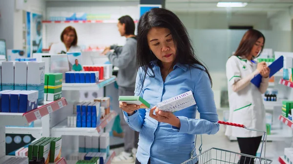 Asian Woman Examining Boxes Medicine Pharmacy Shelves Looking Buy Prescription — Zdjęcie stockowe