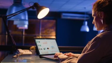 Ofis çalışanı mali grafiklerle çalışıyor, istatistikleri iş alanındaki diyagramlarla analiz ediyor. Yönetici analitiğe yatırım yapmayı planlıyor. Kârın artmasına yardımcı oluyor. El kamerasıyla..