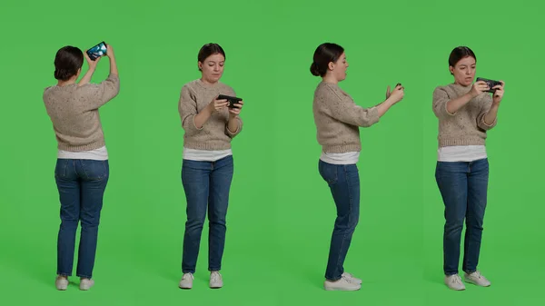 Женская Модель Играющая Видеоигры Онлайн Смартфоне Стоящая Зеленом Фоне Развлекающаяся — стоковое фото