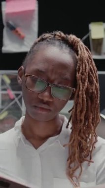 Dikey video: Polis memuru ofiste suç kayıtlarını okuyor, detayları ve ipuçlarını ortaya çıkarmaya çalışıyor. Kanun uygulayıcı ajan dava bilgilerini inceliyor, adli kanıt görüşünü araştırıyor..