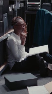 Dikey video: Hukuk müfettişleri sabıka kayıtlarını inceliyor, şüpheli bulmak ve suçu çözmek için dosyaları inceliyor. Gözetim fotoğraflarını inceleyen özel dedektiflerden oluşan bir ekip