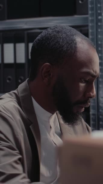 Vertikal Video Afrikansk Amerikansk Man Arbetar Med Brottmål Med Filer — Stockvideo