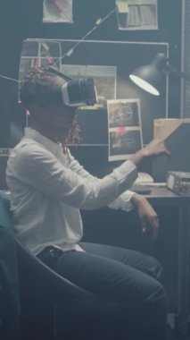 Dikey video: Olay odasında 3 boyutlu vr kulaklık kullanan genç araştırmacı, yeni ipuçlarını ortaya çıkarmak için interaktif sanal gerçeklik gözlükleri kullanıyor. Polis memuru adli kanıtları kontrol ediyor ve dedektiflik yapıyor.