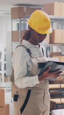 Dikey video: Barkodları tarayan, karton kutularda paketlenmiş ürünlere bakan çok ırklı işçilerden oluşan bir ekip. Erkek çalışan, malları denetleyiciye getiriyor, sevkiyat planlıyor..