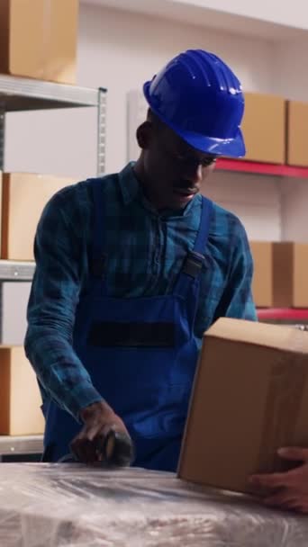 垂直ビデオ 物流や在庫のためのスキャナーとタブレットを使用して多様な男性のチーム 倉庫内の貨物のバーコードをスキャンします ストックルームで働いてる若者達 — ストック動画