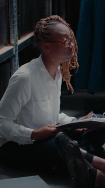 Dikey video: İçinde adli kanıtlar ve ipuçları olan polis soruşturması üzerinde çalışan Afrikalı Amerikalılar. Müfettişlerden oluşan bir ekip fotoğrafları inceleyip şüphelilerin geçmişini araştırıyor.