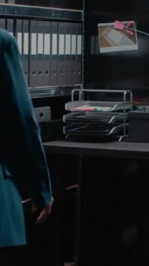 Dikey video: Adli tıptan delilleri analiz eden kadın dedektif, fotoğraflı haritaya ve davayı çözmek için ipuçlarına bakıyor. Özel dedektif hukuk bürosundaki güvenlik bilgilerini inceliyor..