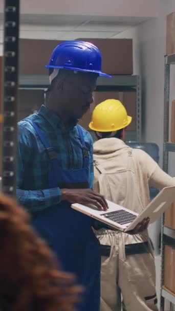 Вертикальне Відео Африканський Американець Використовує Ноутбук Сховищі Працюючи Над Матеріалами — стокове відео
