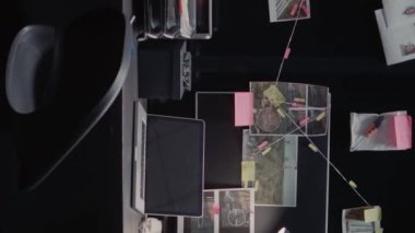 Dikey video: Polis arşiv duvar haritası, gözetleme kayıtları ve tanık ifadeleriyle ilgili dosya veya soruşturma ipuçlarının yer aldığı kanıt panosu. Suç kayıtlarıyla dolu boş bir kolluk kuvveti..