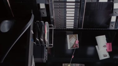 Dikey video: Dedektif kanıt haritası arşiv odasındaki duvarda dava ipuçları, suç mahalli fotoğrafları ve güvenlik kamerası görüntüleri. İfadeler ve kayıtlarla dolu boş bir polis bürosu..