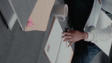 Dikey video: Kadın müfettiş dava dosyaları hakkında bilgi okuyor, ipuçları ve gözetim fotoğraflarıyla suçu çözmeye çalışıyor. Polis memuru adli kanıtları inceliyor. Şüpheli geçmişini araştırıyor..