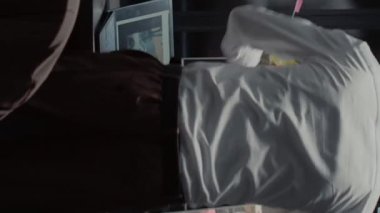 Dikey video: Afro-amerikan hukuk ajanı olay odasında özel soruşturma yürütmeye çalışıyor. Genç bir polis memuru haritadaki fotoğrafları ve adli kanıtları inceliyor.