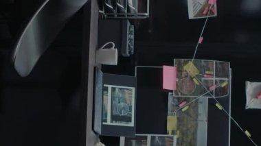 Dikey video: Kadın polis memuru dava dosyalarına not alıyor, suçu çözmeye çalışıyor ve şüpheliyi bulmaya çalışıyor. Profesyonel dedektif kanıt fotoğraflarına, tanık ifadelerine, adli tıp uzmanlığına bakıyor..