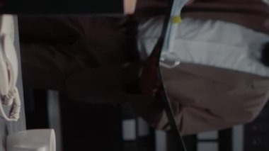 Dikey video: Olay odasında polis arşiv kayıtları olan klasör araştırmacısı. Özel dedektif dava dosyalarını okuyor, adli kanıtları ve tanık ifadelerini analiz ediyor..