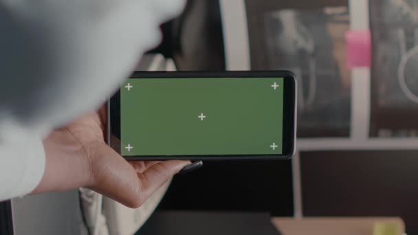 垂直视频 私家侦探手持带有绿屏的智能手机 女警察凝视着孤立的彩色显示屏 办公室里的调查员使用着色键模型模板 — 图库视频影像