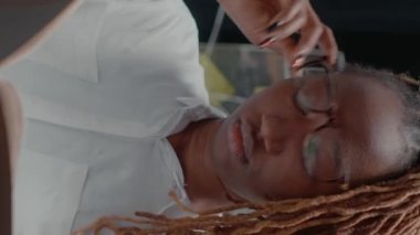 Dikey video: Profesyonel ajan dosyalardaki delilleri inceliyor, gözetim fotoğrafları ve suç bilgileriyle raporları tutuyor. Dedektif davayı çözmeye çalışıyor, yasal soruşturma yürütüyor.