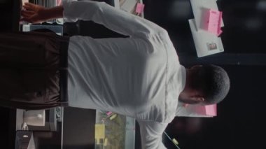 Dikey video: Dedektif gemide suç dosyalarını ve fotoğraflarını analiz ediyor, şüpheliyi bulmak için içgörü araştırıyor. Polis müfettişi adli delillere ve şüpheli ipuçlarına bakıyor, ifadeleri okuyor..