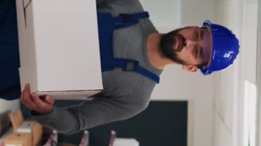 Dikey video: Çeşitli çalışanlardan oluşan bir ekip barkodları tarıyor, karton paketlerdeki ürünlere bakıyor. Ürünleri denetleyiciye getiren iki kişi, malları taramak için dijital tablet kullanıyor.