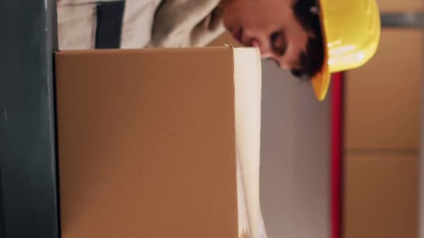 垂直录像 年轻的仓库工人在包装上贴上胶带 在仓库空间用商品准备定单 男性主管用货物 送货服务密封纸板箱 — 图库视频影像