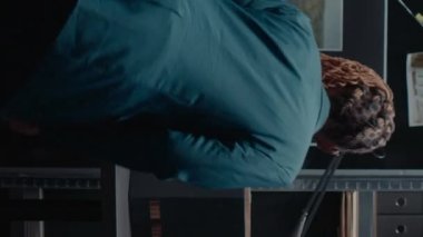 Dikey video: Afro-amerikan kadın olay odasındaki dava kayıtlarını analiz ediyor, fotoğrafları ve adli kanıtları inceliyor. Güvenlik görevlisi gözetim bilgilerine bakıyor, detaylara.