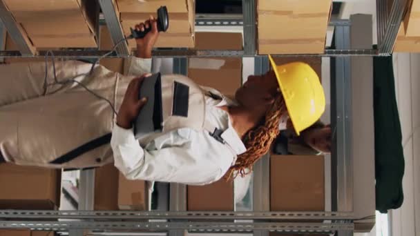 垂直视频 年轻妇女扫描包装上的条形码 以进行库存物流工作 使用扫描仪和检查装运货物 女雇员看着货架上的分娩箱 — 图库视频影像