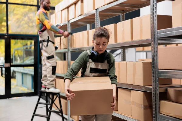 工作人员携带纸板箱在储藏室工作 准备网上订购单 仓库主管在向客户发货前进行产品质量控制 仓库概念 — 图库照片