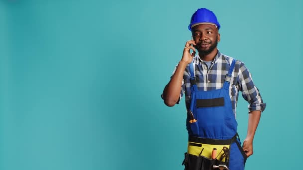 Αφροαμερικάνος Ξυλουργός Μιλάει Στο Τηλέφωνο Στο Στούντιο Σχεδιάζει Νέο Κατασκευαστικό — Αρχείο Βίντεο