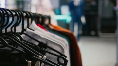 Modern perakende mağazasında asılı resmi kıyafet çeşitliliği, boş giyim mağazası veya modaya uygun ürünlerle dolu bir butik. Modern mağaza, küçük işletme konsepti. Kapat..