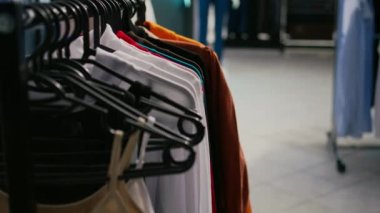 Giyim mağazasında asılı birden fazla resmi ya da günlük kıyafet, modaya uygun ürün ve ürünlerle dolu emoty alışveriş merkezi butiği. Moda küçük işletme konsepti. Kapat..