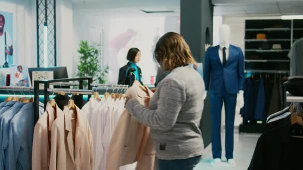 Neşeli Kadın Giyinmek Için Soyunma Odasına Gidiyor Alışveriş Merkezindeki Askılarda — Stok video