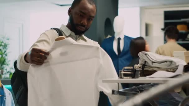 Afrykański Amerykański Klient Analizuje Ubrania Akcesoria Sklepie Odzieżowym Patrząc Kolekcję — Wideo stockowe