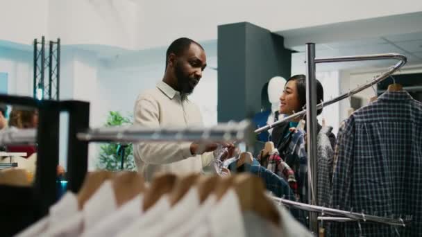 Eine Arbeiterin Zeigt Dem Kunden Geschäft Kleidung Und Sucht Nach — Stockvideo