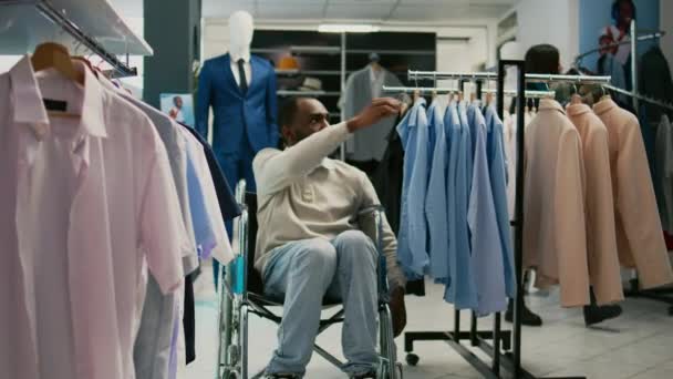 Cliente Masculino Cadeira Rodas Olhando Para Roupas Moda Loja Varejo — Vídeo de Stock