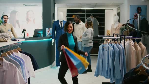 亚洲客户带着购物袋跳舞 在收银机购物后感到开心 年轻女子在购物中心跳舞和买时髦衣服 三脚架射击 — 图库视频影像