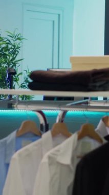 Dikey video: Alışverişkolik müşteriler için boş moda galerisi, giyim mağazasında ürünleri olan küçük işletme konsepti. Perakende pazarında resmi giyim koleksiyonları, tüketim